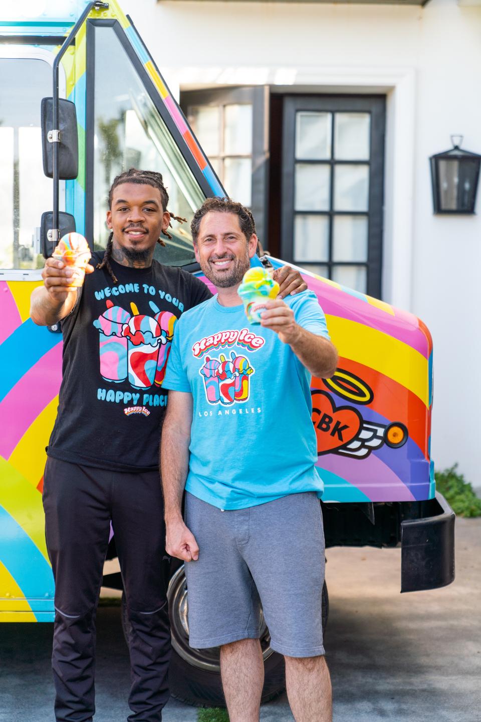 Lemeir Mitchell, left, and Ted Foxman, right, holding up water ices by a Happy Ice truck