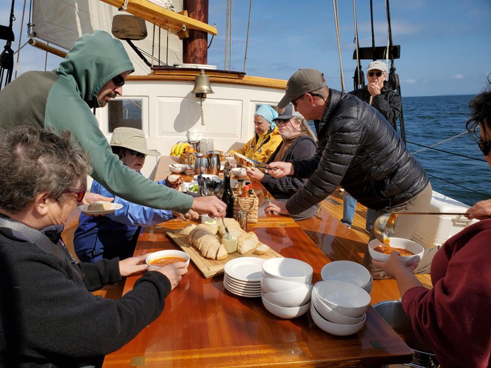 Guests gather on deck as chef Anna Miller serves bowls of fresh tomato bisque.