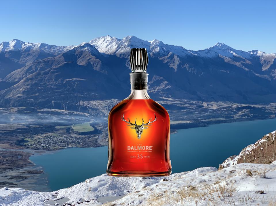 A brilliant orange-amber hued bottle sits among the snowcapped mountains of New Zealand